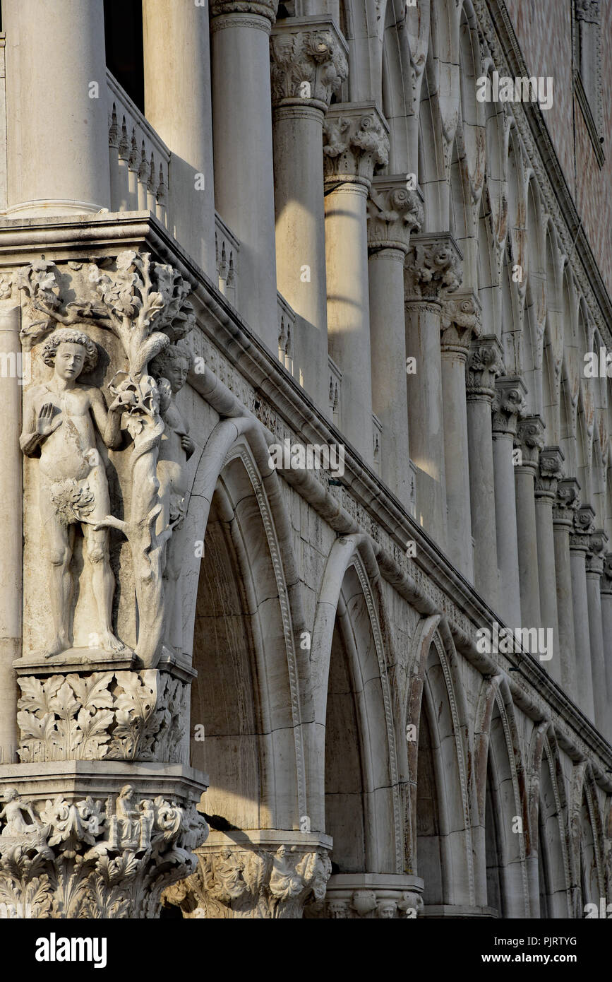 La lumière de début de soirée met en lumière cette sculpture d'Adam et Eve avec le serpent à l'angle de du palais des Doges, Venise, Italie. L'Europe. Banque D'Images