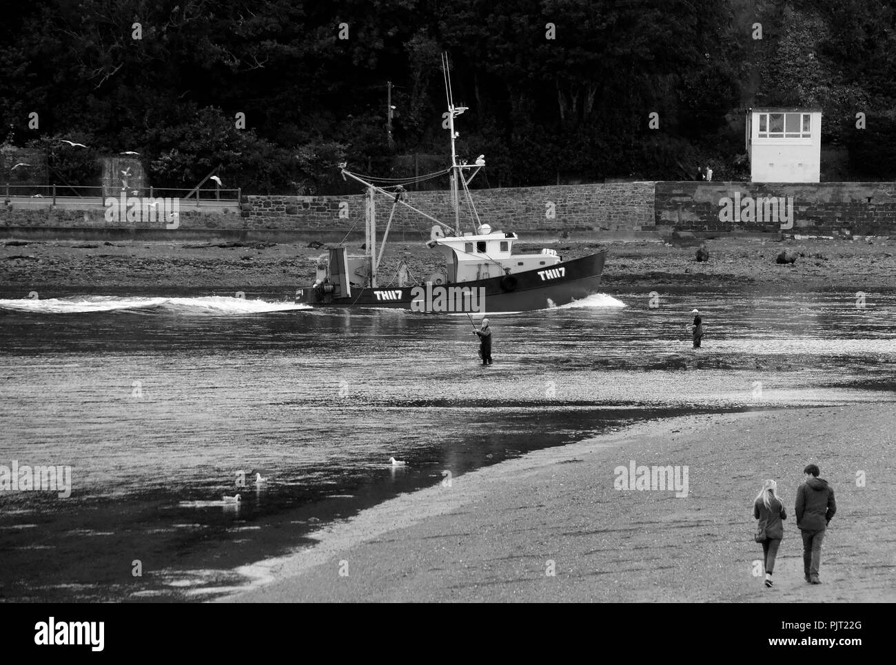 Un des petits bateaux de pêche pousse son chemin dans Teignmouth port grâce à l'évolution rapide de la race des marées. Banque D'Images