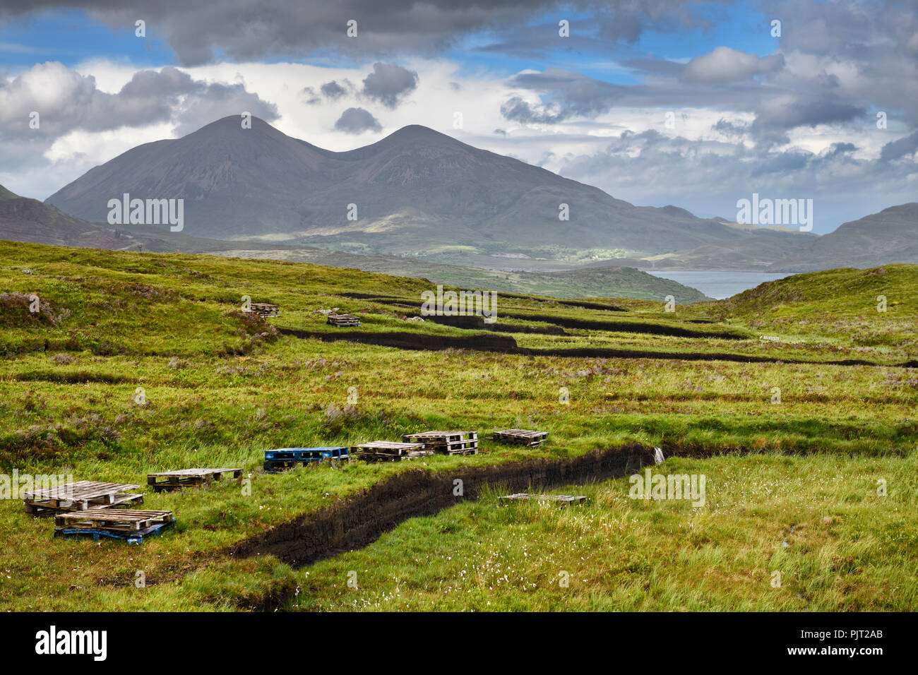 Tranchées découpées en tourbe profonde de milieux humides moors près de Drinan sur l'île de Skye en Écosse avec le Loch Beinn Na Caillich Slap et pic de montagne Banque D'Images