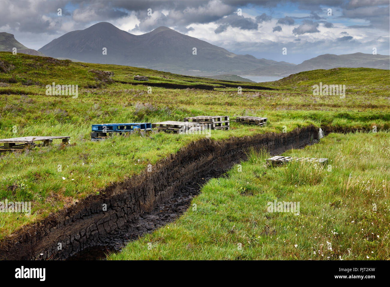 Tranchées découpées en tourbe profonde de milieux humides moors près de Drinan sur l'île de Skye en Écosse avec Slap et Loch Beinn Dearg Mhor et Beinn Na Caillich peaks Banque D'Images