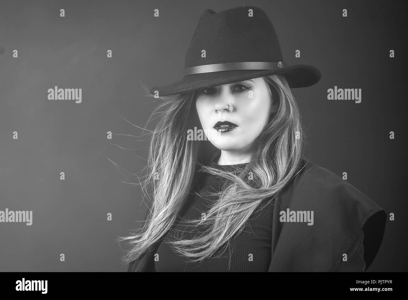 Portrait d'une femme rousse dans un manteau noir et hat looking at camera Banque D'Images
