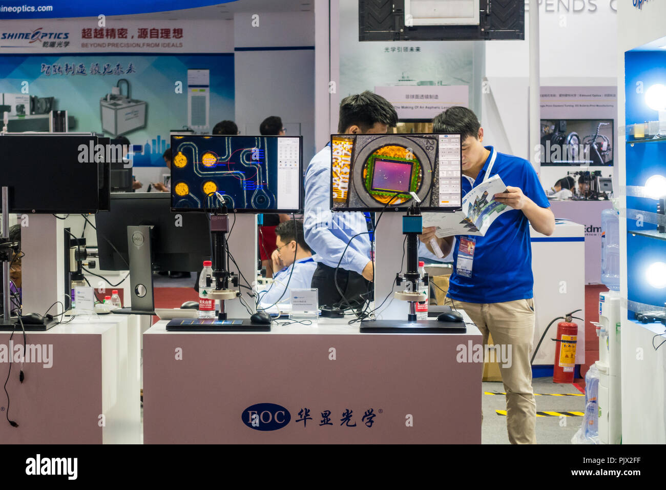 Les vendeurs chinois parler d'affaires des ventes de produits de haute technologie en Chine optoélectronique Expo à Shenzhen, Chine. Banque D'Images