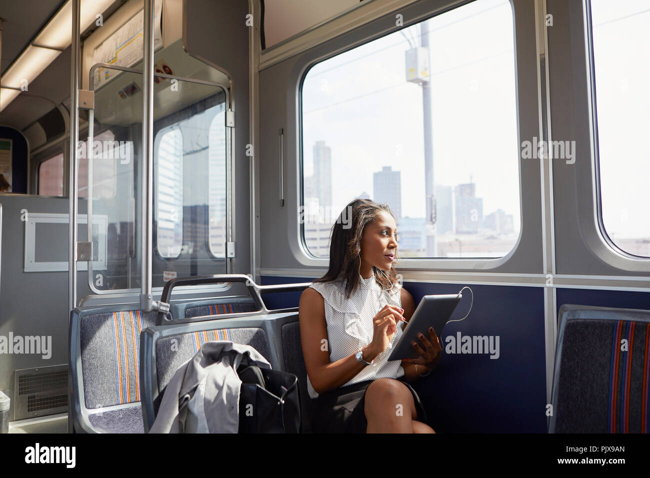 Businesswoman using digital tablet on train Banque D'Images