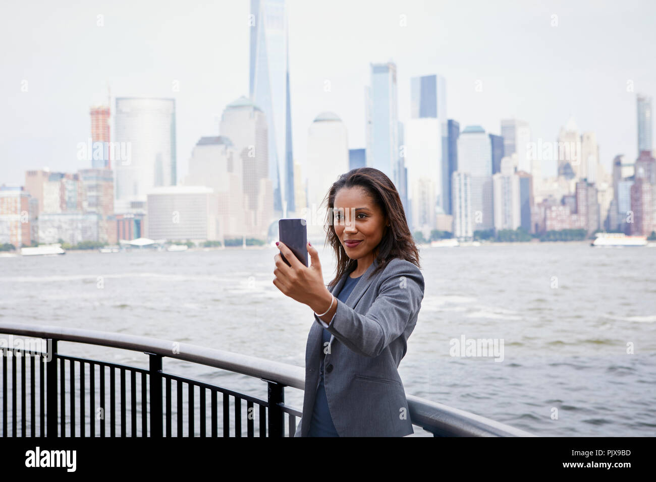Businesswoman prenant, selfies New York City Skyline in background Banque D'Images