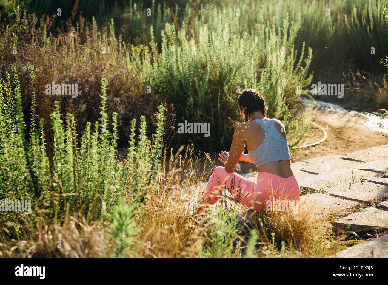 Woman relaxing parmi les arbustes Banque D'Images