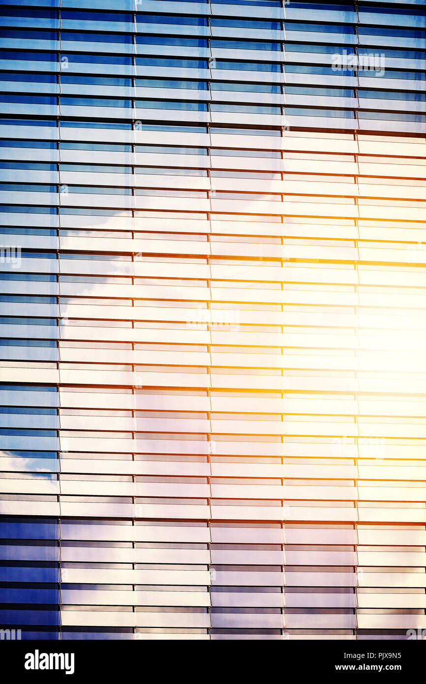 Coucher du soleil reflétée dans un bâtiment à la façade de verre, couleur tonique photo. Banque D'Images