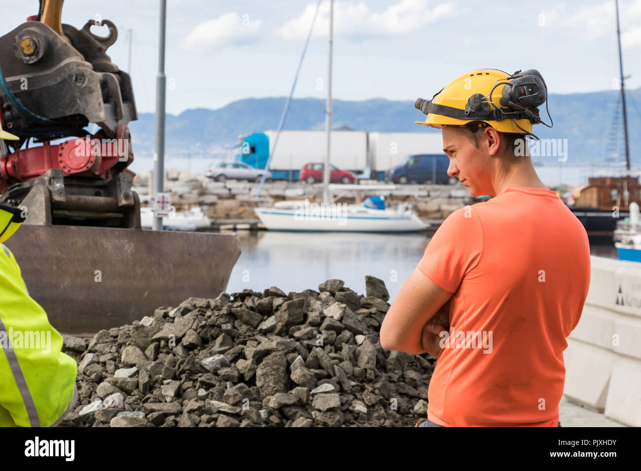 Trondheim, Norvège - Août 28th, 2018 : un jeune travailleur de la construction à St Brattorkaia portant un casque et une protection auditive, casque radio Banque D'Images