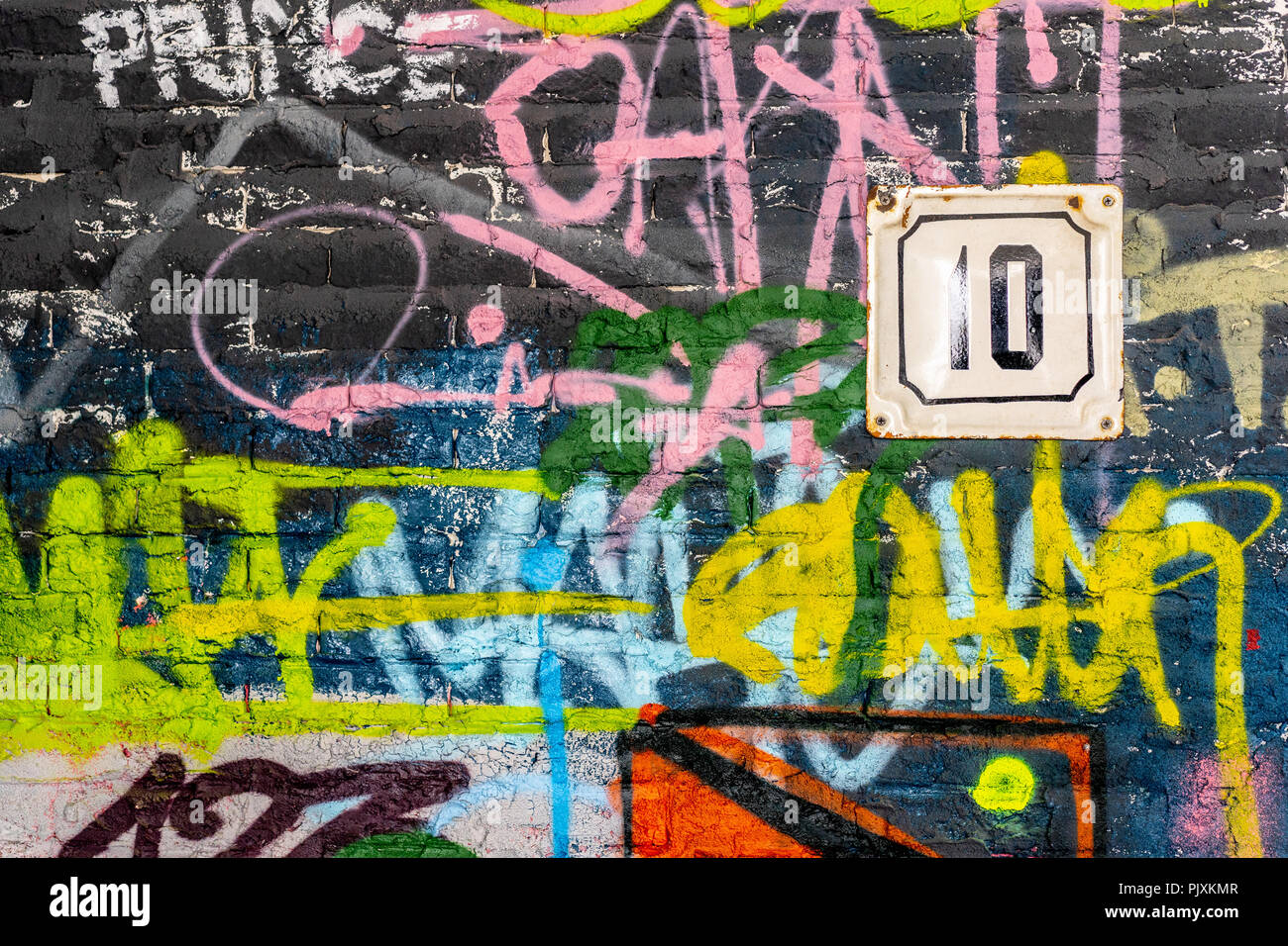 Un mur de graffitis d'artistes inconnus. Numéro de la maison sur le mur. L'art de rue Copyspace pour le texte et le design. Banque D'Images
