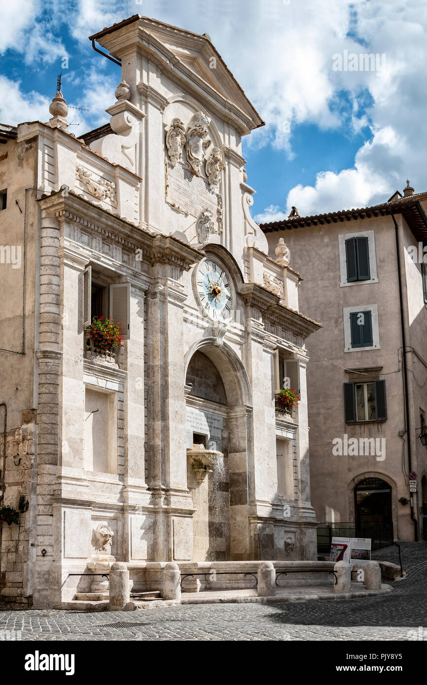 L'ancienne fontaine de travertin de la Piazza del Mercato avec l'ancienne tour de l'horloge artistique. Spoleto - UMBRIA, Italie Banque D'Images