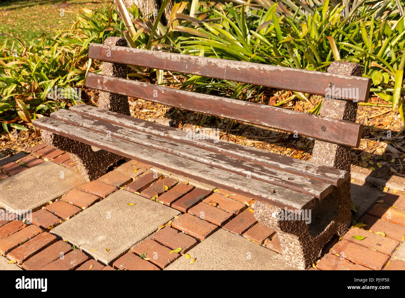 Un vieux assis double piscine avec chaise et ardoises en bois pavage en béton sur les côtés dans un parc Banque D'Images