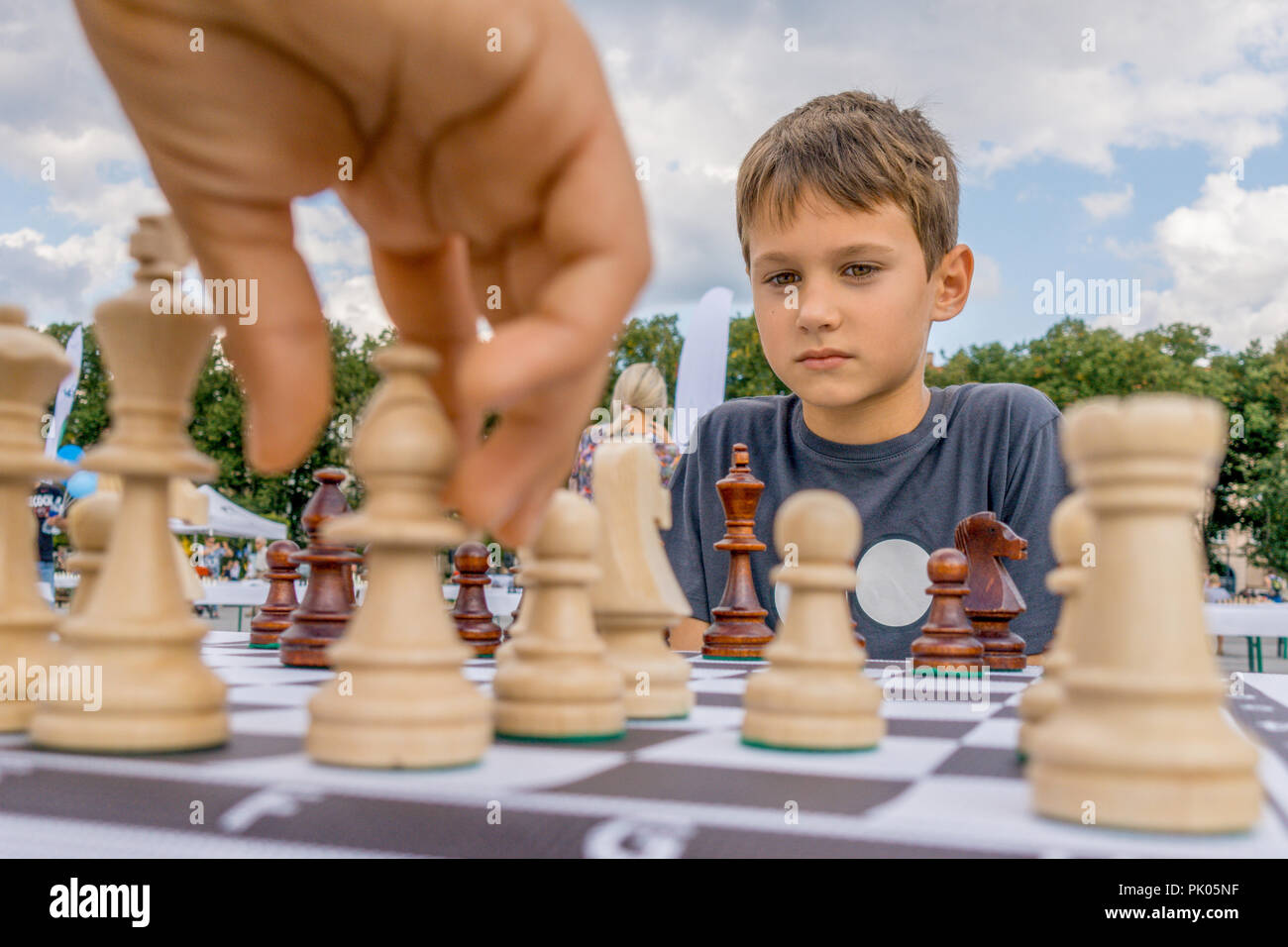 Enfants jouant aux échecs à l'extérieur. échiquier Boy thinking dur sur les combinaisons d'échecs Banque D'Images