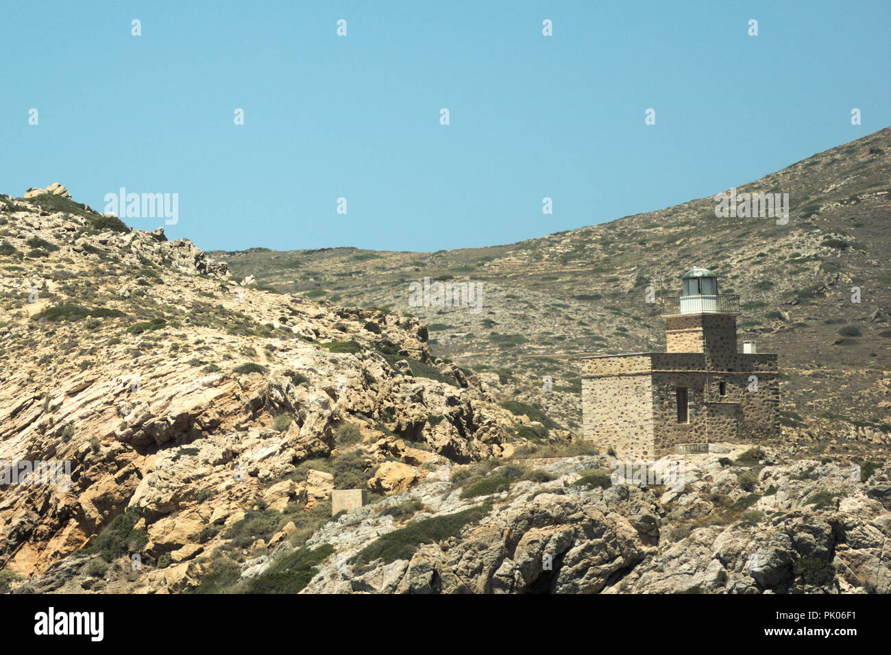 Grèce, la jolie île d'iOS. L'ancien phare est sentinelle et garde le port Banque D'Images
