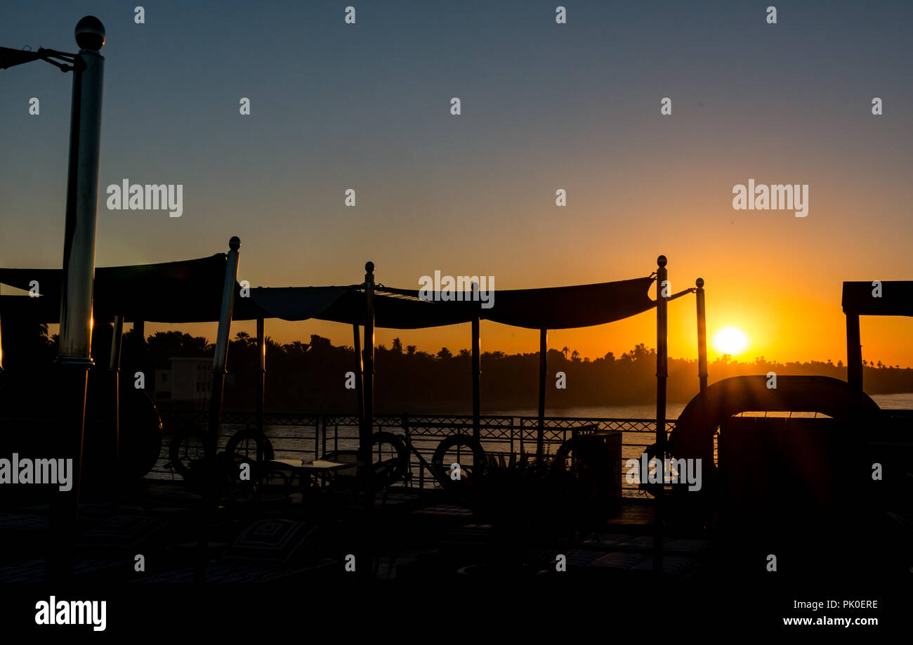 Vue du coucher de soleil pont du navire de croisière de la rivière avec des silhouettes d'ombres d'ébarbage, Nil, l'Egypte, l'Afrique Banque D'Images
