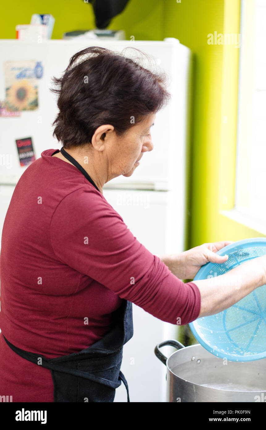 Senior woman la préparation des aliments sains accueil à partir de légumes frais dans la cuisine. Banque D'Images