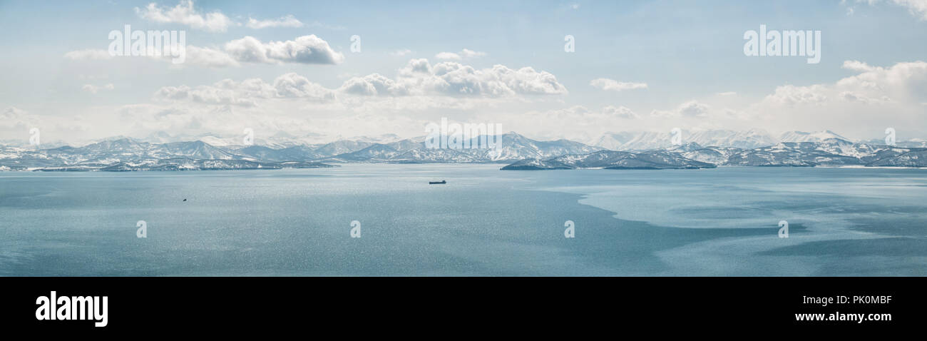 Panorama de la Baie d'Avacha recouvert d'une fine couche de glace à Yichun et vue sur les collines couvertes de neige et de volcans en hiver par temps clair Banque D'Images