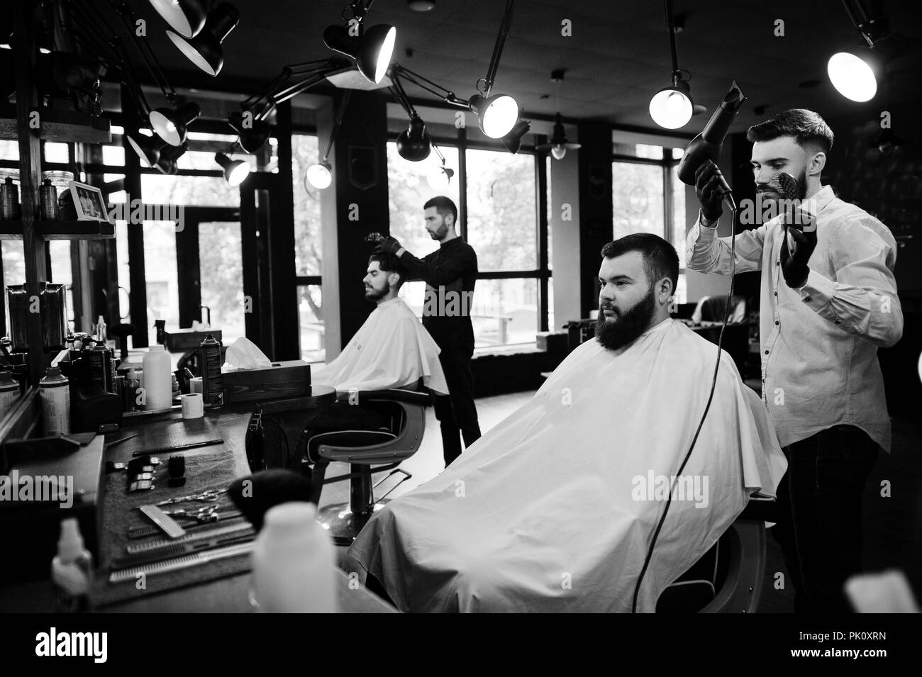 Beau barbu au salon de coiffure, salon de coiffure au travail, à l'aide d'un sèche-cheveux. Banque D'Images