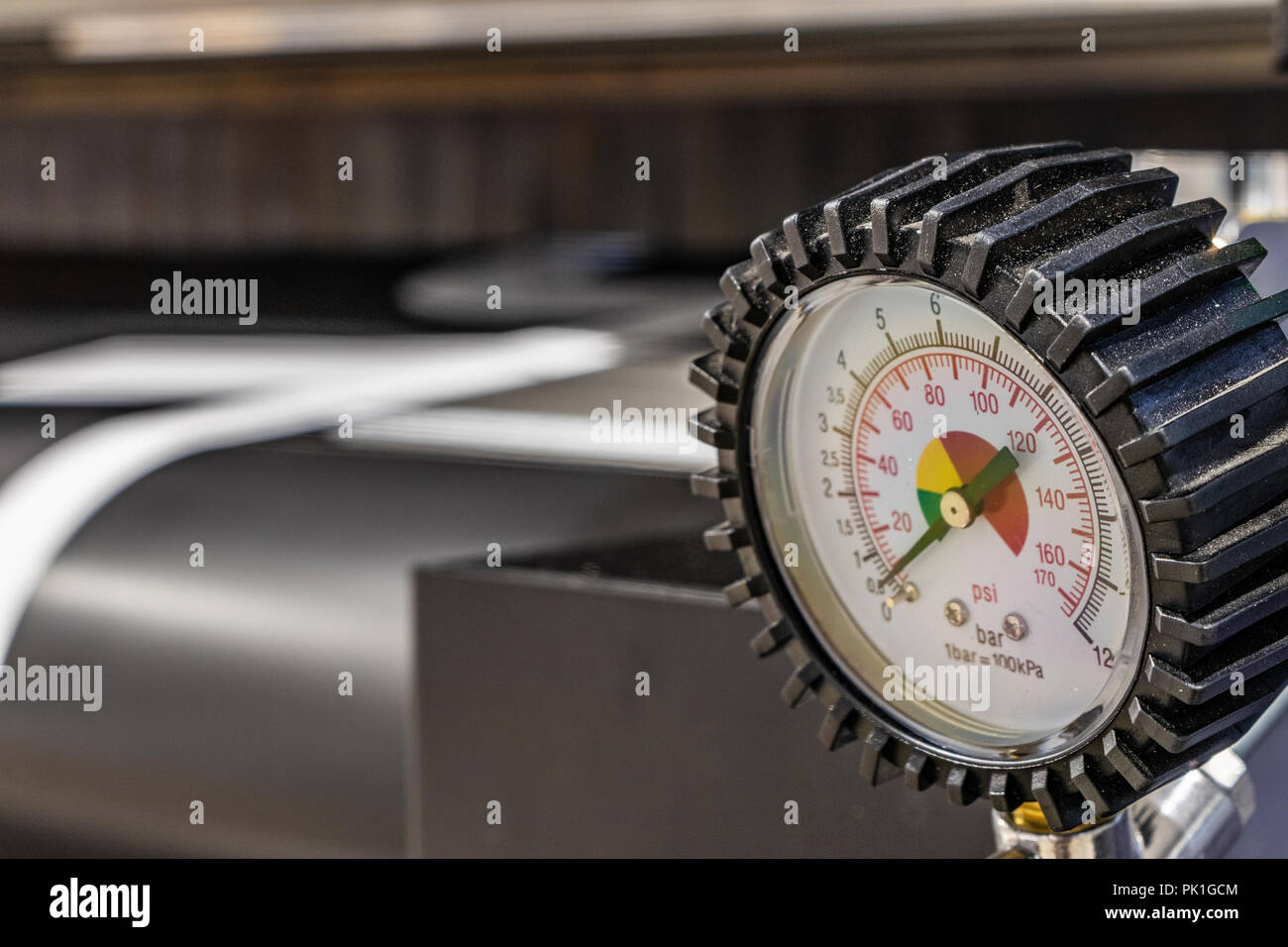 Détail d'un instrument de contrôle de la pression dans les grandes installations d'impression. Masive floue, tube noir en arrière-plan. Banque D'Images
