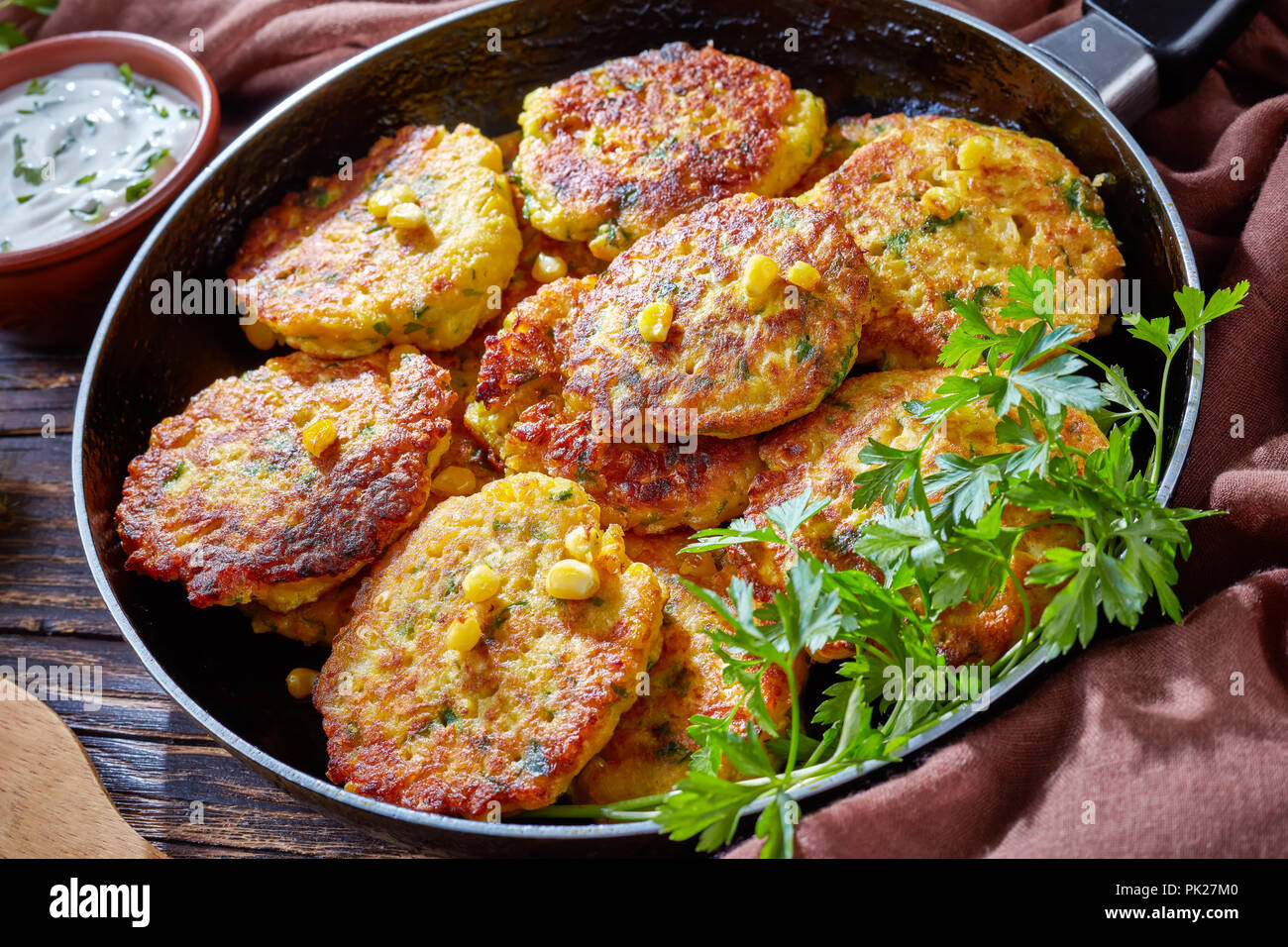 Beignets de maïs dans une poêle avec sauce trempette au yogourt à l'arrière-plan, Vue de dessus, close-up Banque D'Images