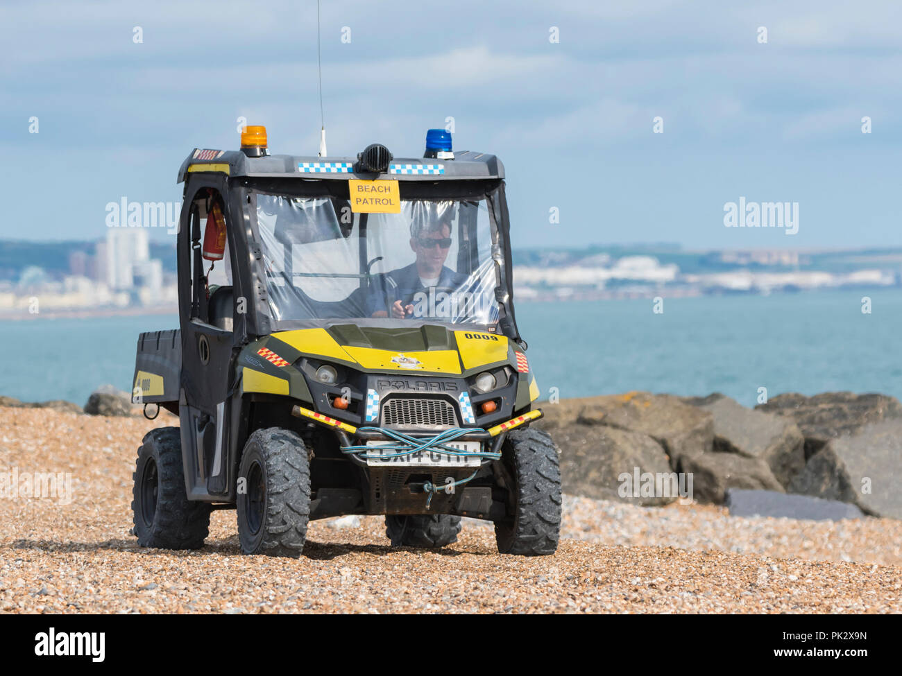 Polaris Sportsman 400 4x4 véhicule utilitaire léger de patrouille de plage sur une plage de galets sur la côte sud de l'Angleterre, Royaume-Uni. Banque D'Images