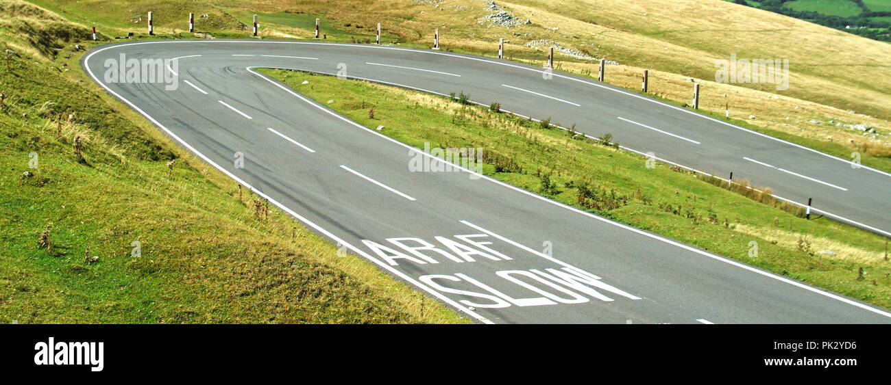 Le Parc National des Brecon Beacons vide non clôturées moorland road épingle lente panneau d'avertissement multilingue bilingue marqués sur la route vallonnée South Wales UK Banque D'Images