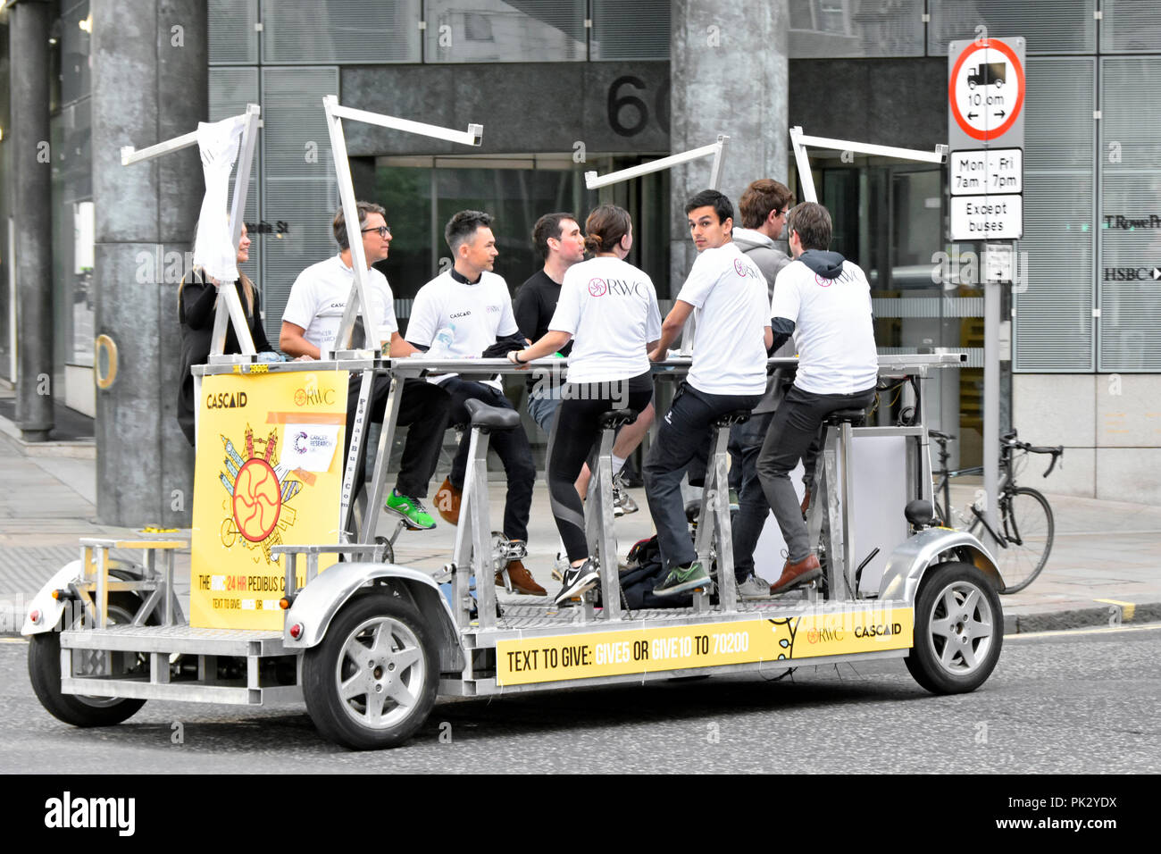 Chuggers ou charité détrousseurs groupe de jeunes gens sur la gestion des actifs à Pedibus pédale le long de la rue de Londres pour recueillir des fonds pour la charité Cascaid Banque D'Images