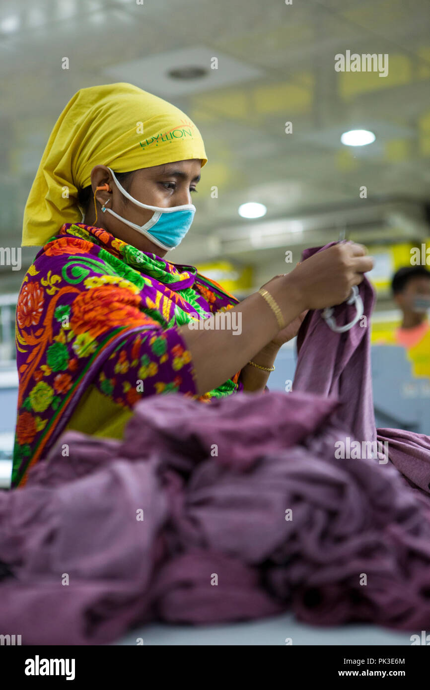 Une travailleuse du vêtement au travail sur une machine à l'intérieur d'une usine de confection au Bangladesh. Banque D'Images
