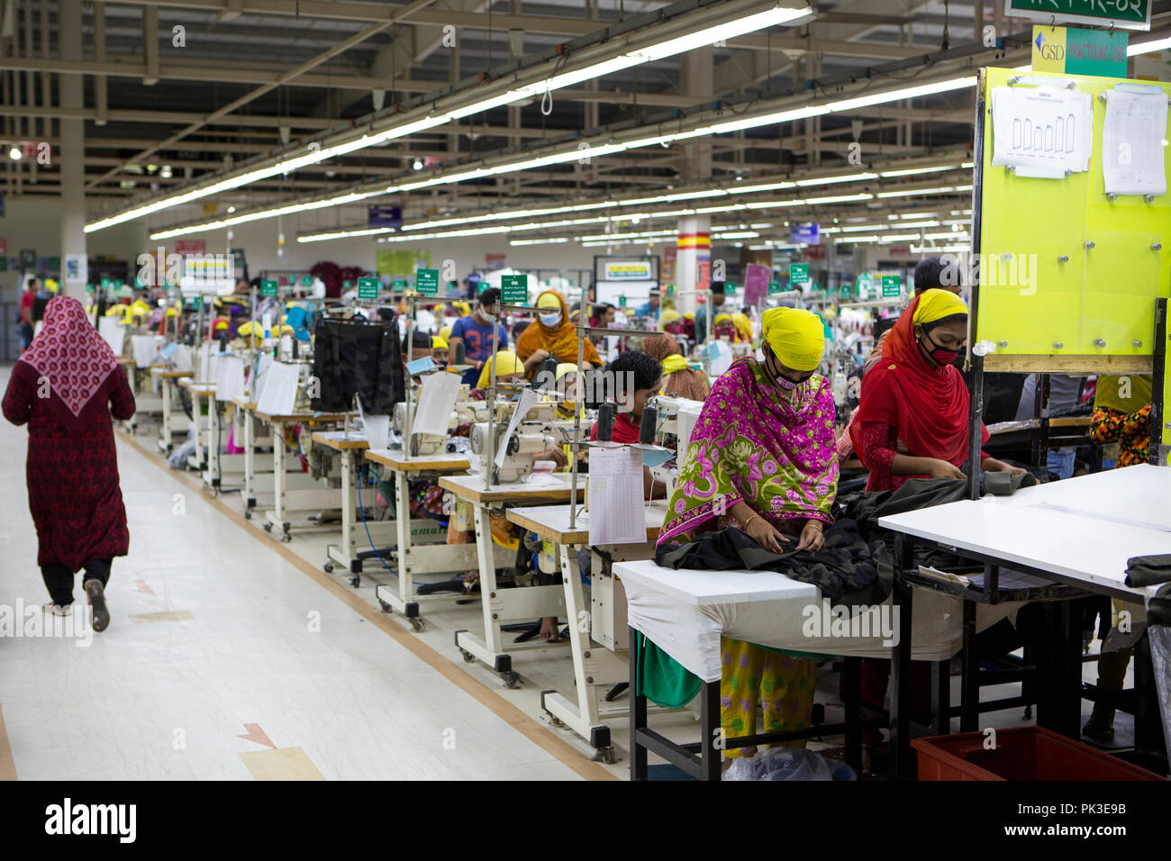 Les travailleurs du vêtement au travail sur machines à coudre à l'intérieur d'une usine de confection au Bangladesh. Banque D'Images