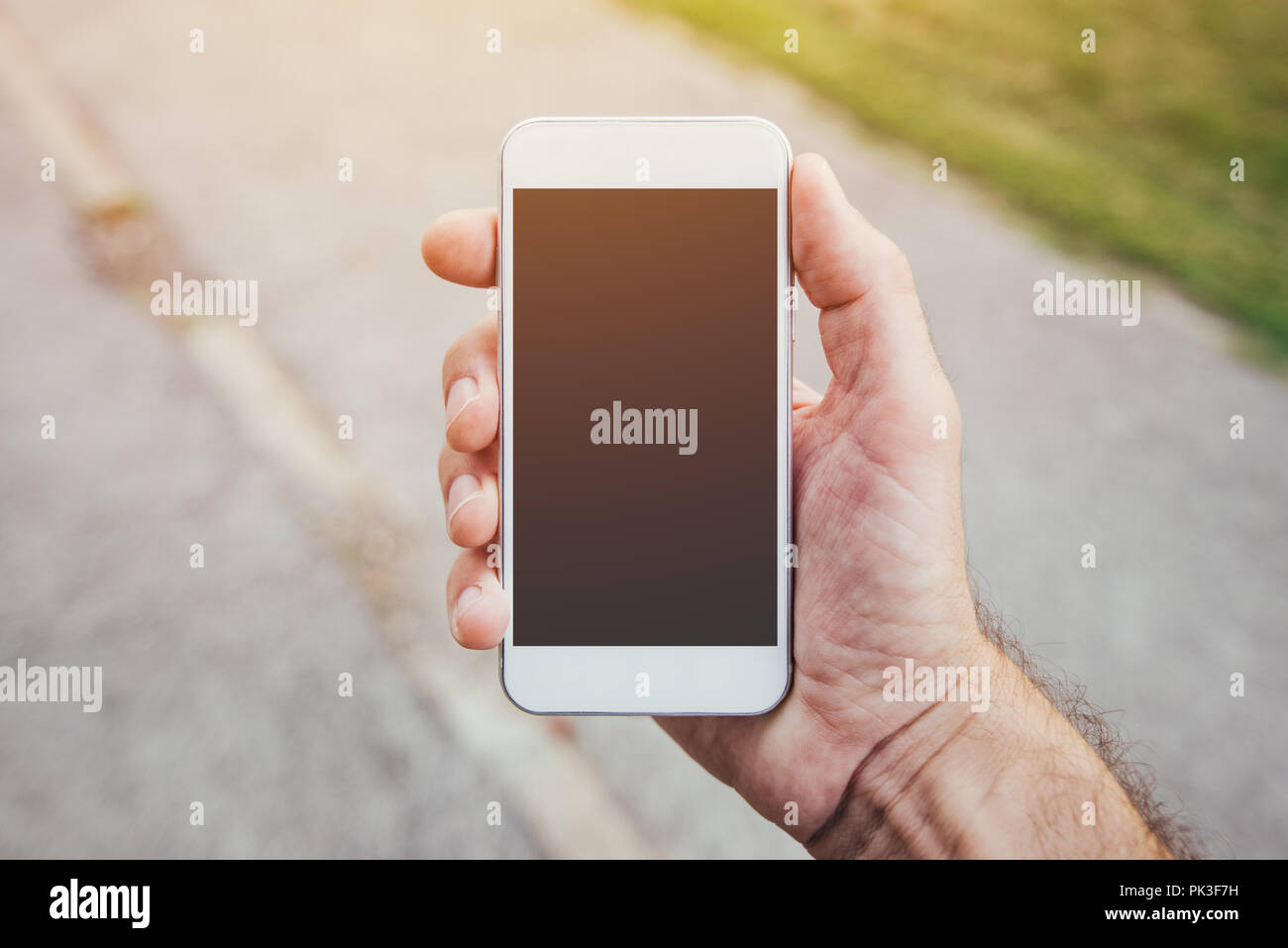 La main avec la maquette du smartphone copie espace, l'homme à l'aide de téléphone mobile contemporain moderne dans la rue en milieu urbain Banque D'Images