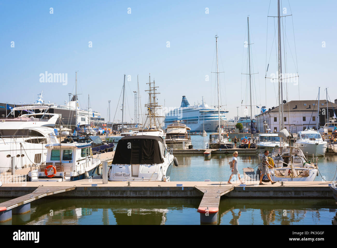 Port de Tallin, vue sur une journée d'été d'un couple d'âge moyen marche sur une jetée dans la marina du port de Tallinn, Estonie. Banque D'Images