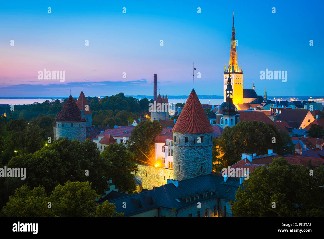 Tallinn, vue nocturne du quartier médiéval de la Basse-ville avec l'église Saint OLAF illuminée au loin, Tallinn, Estonie. Banque D'Images