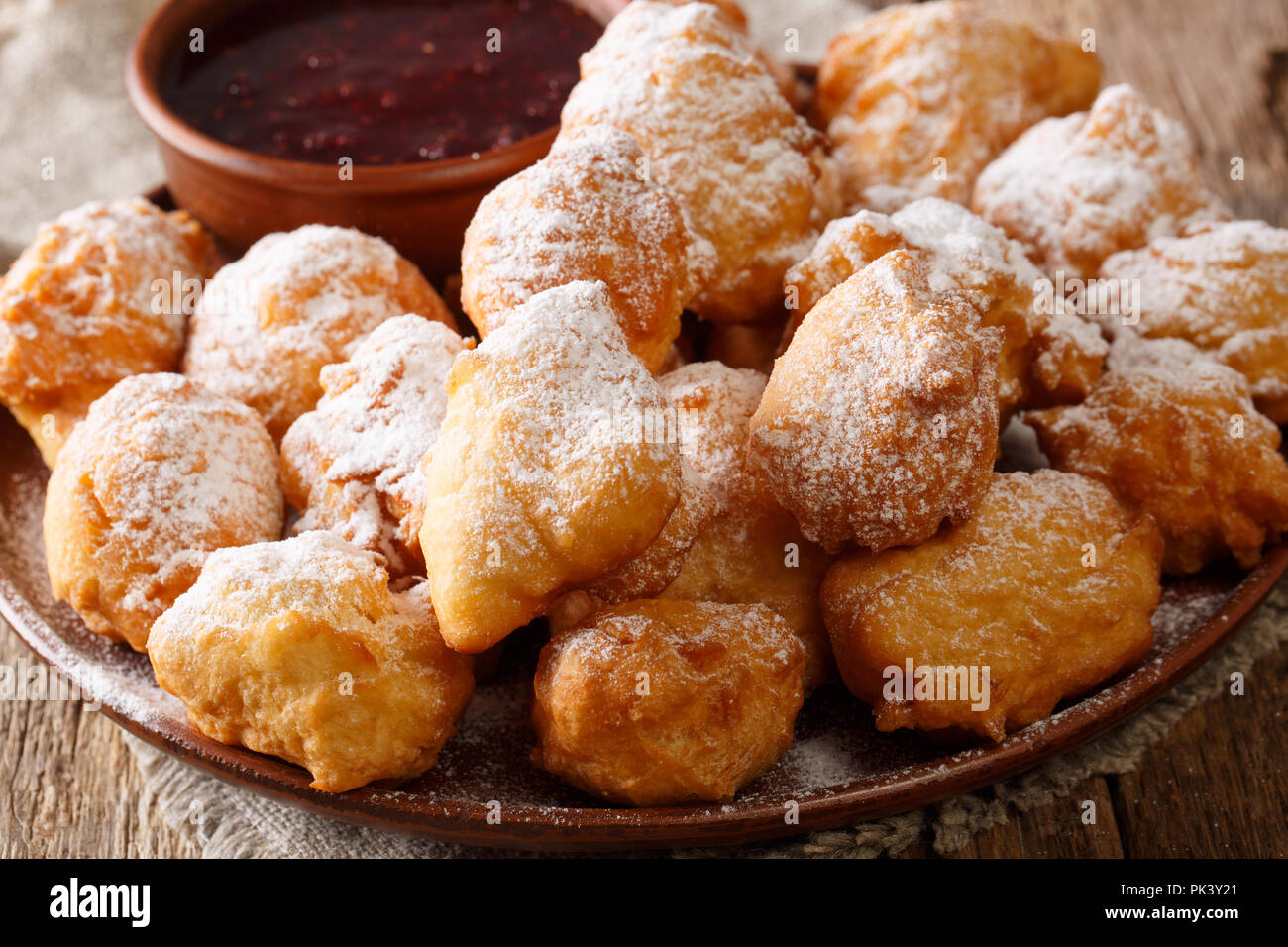 Recette de pâte frite albanais petulla avec confiture de framboises et de sucre en poudre sur la table horizontale. Banque D'Images