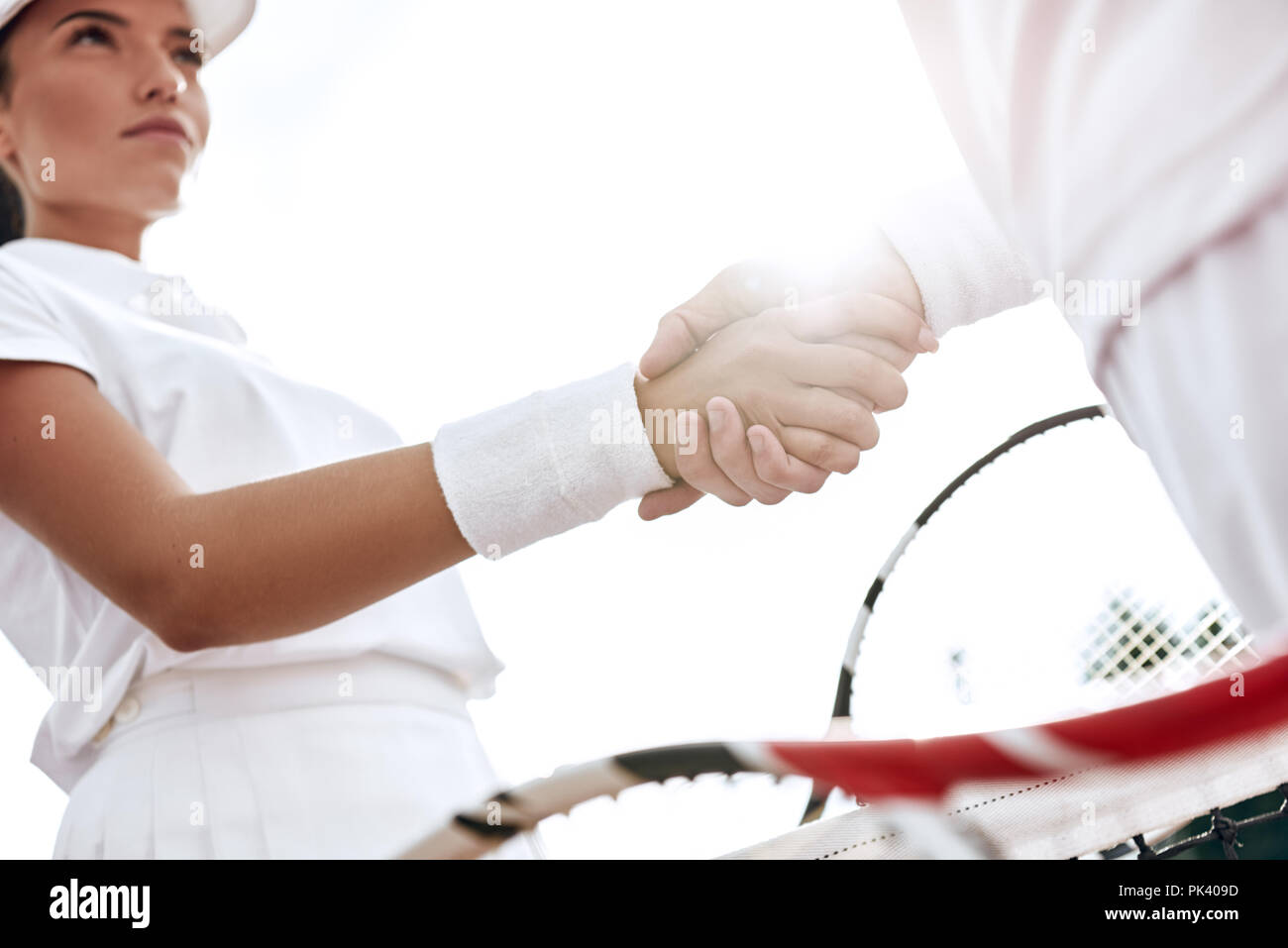 Se serrer la main après un bon jeu. Close-up de l'homme et de la femme en serrant la main bracelet sur le filet de tennis Banque D'Images