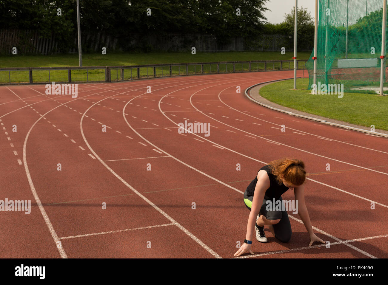 Athlète féminin prêt à fonctionner sur une piste de course Banque D'Images