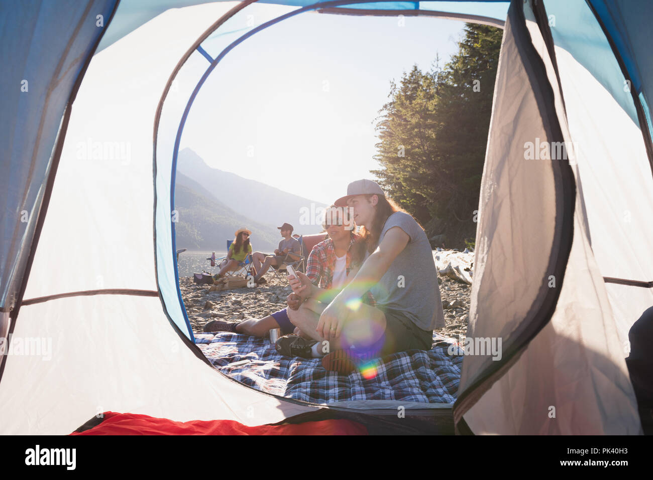 Couple près de tente en campagne Banque D'Images