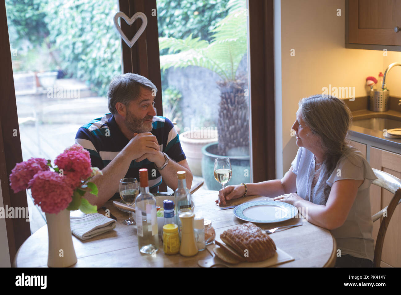 Couple en interaction les uns avec les autres sur une table à manger Banque D'Images