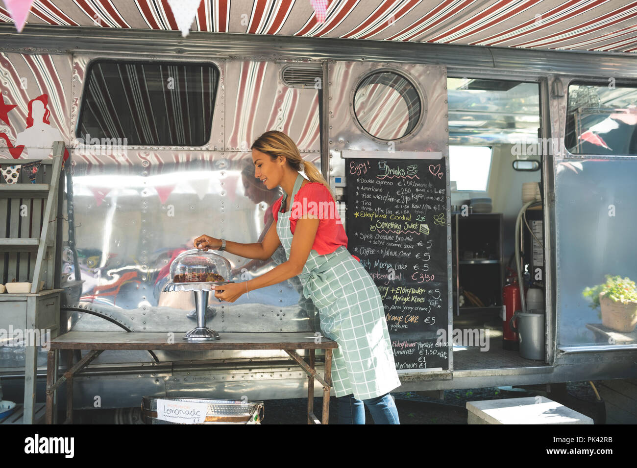 Serveuse femme travaillant à proximité de camion alimentaire Banque D'Images