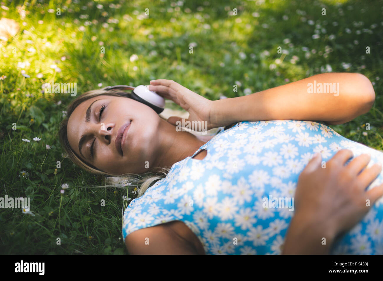 Woman listening music in garden Banque D'Images