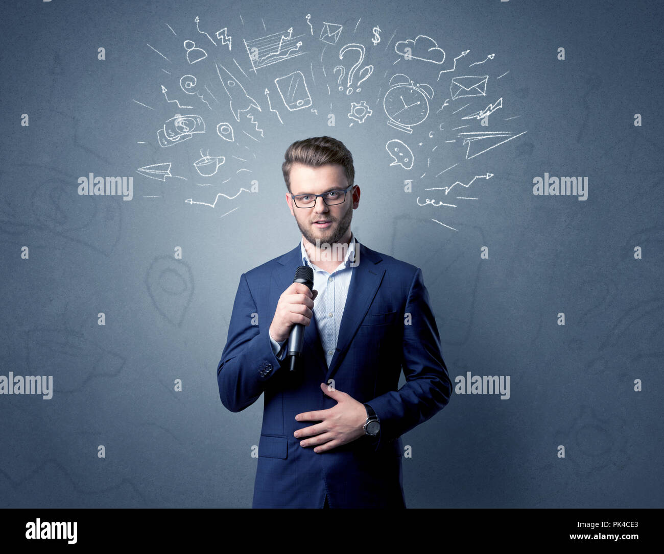 Businessman parlant au micro avec des doodles sur sa tête Banque D'Images