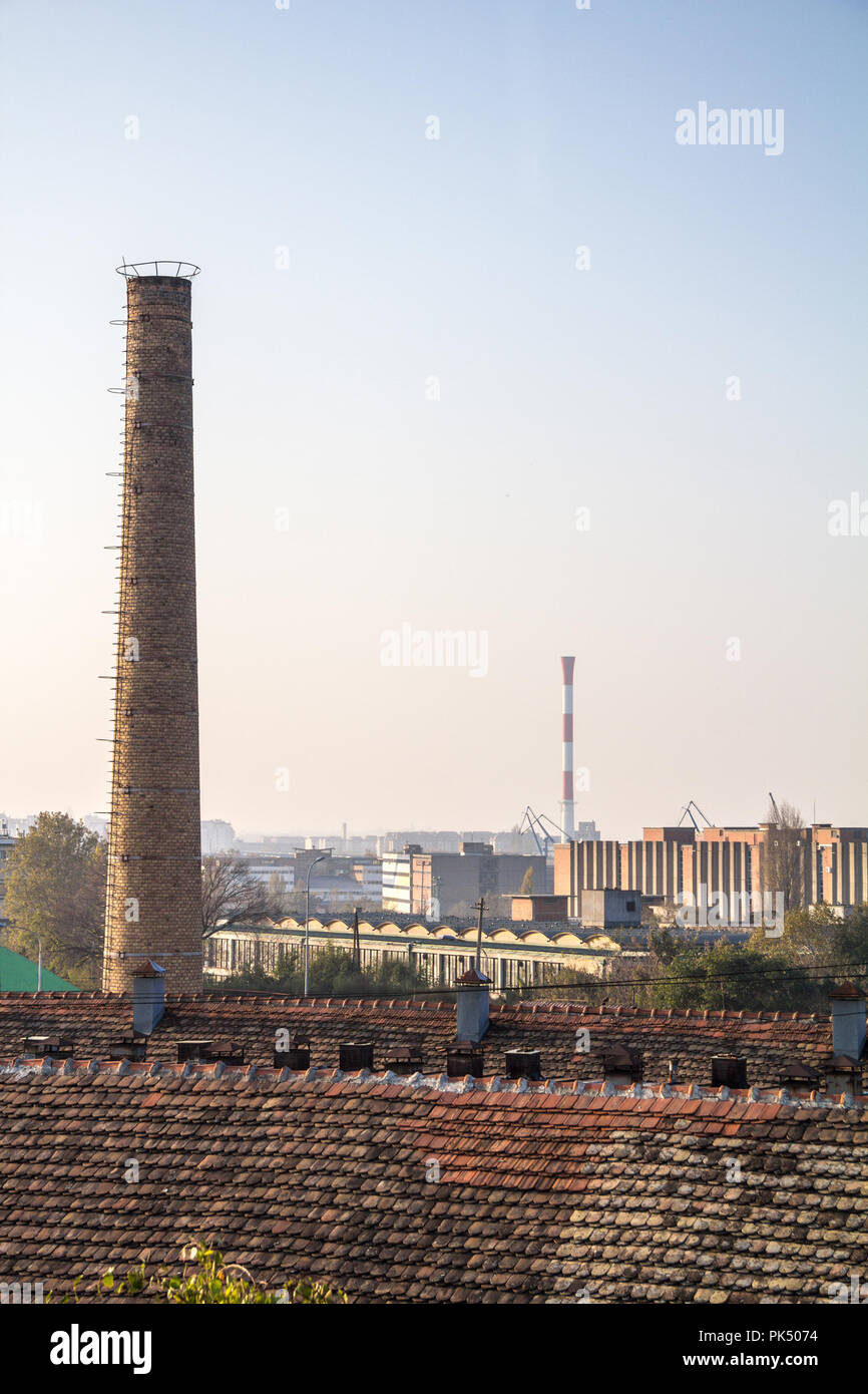 Ancienne cheminée en brique d'une usine abandonnée, à partir de la révolution industrielle, avec plus d'une zone industrielle moderne peut être vu dans l'arrière-plan, en Belg Banque D'Images