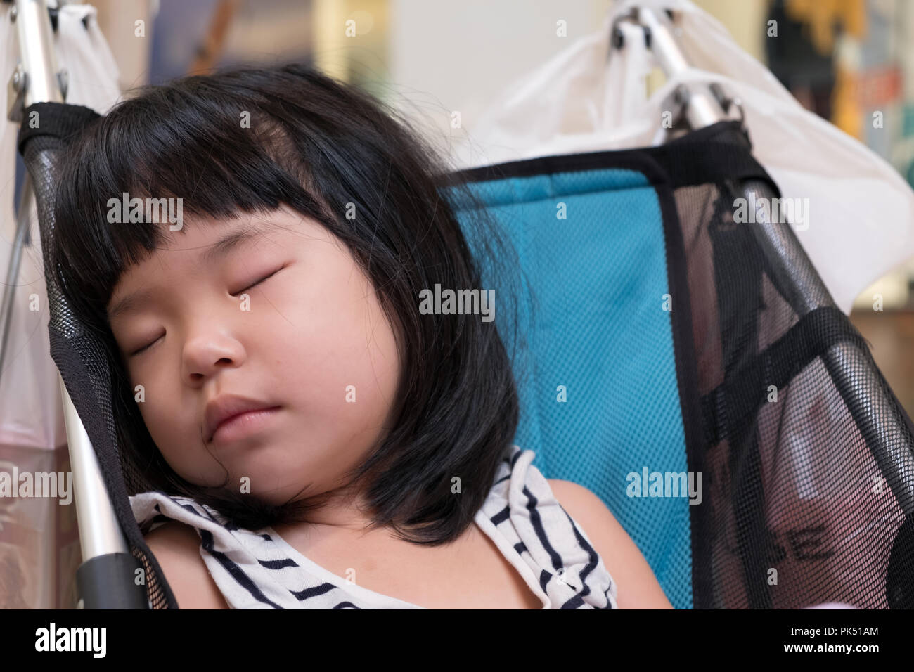 Peu d'Asian baby girl sleeping dans une poussette Banque D'Images