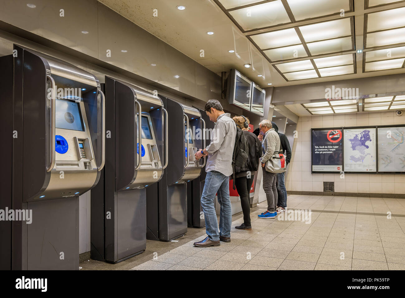 Quatre passagers en face de distributeurs automatiques de billets dans une station de métro de Copenhague, Copenhague, le 6 septembre 2018 Banque D'Images
