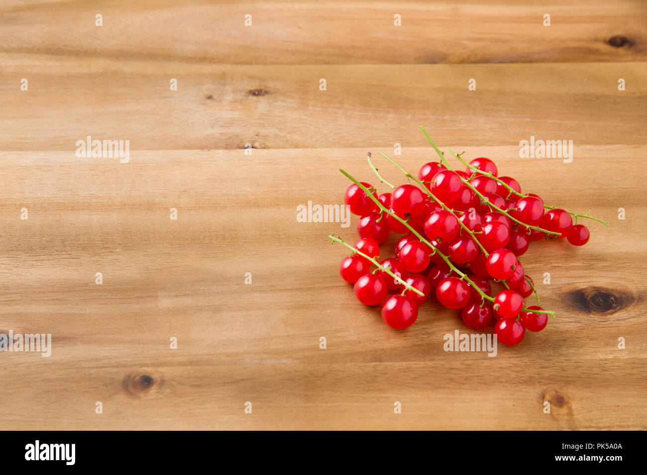 Groseilles rouges frais mûrs isolé sur une planche de bois. Vue de l'avant avec copie espace. Studio Shot Banque D'Images