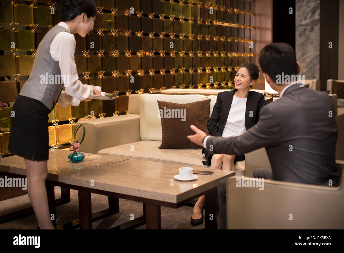 Jeune serveuse servir le café à des gens d'affaires Banque D'Images
