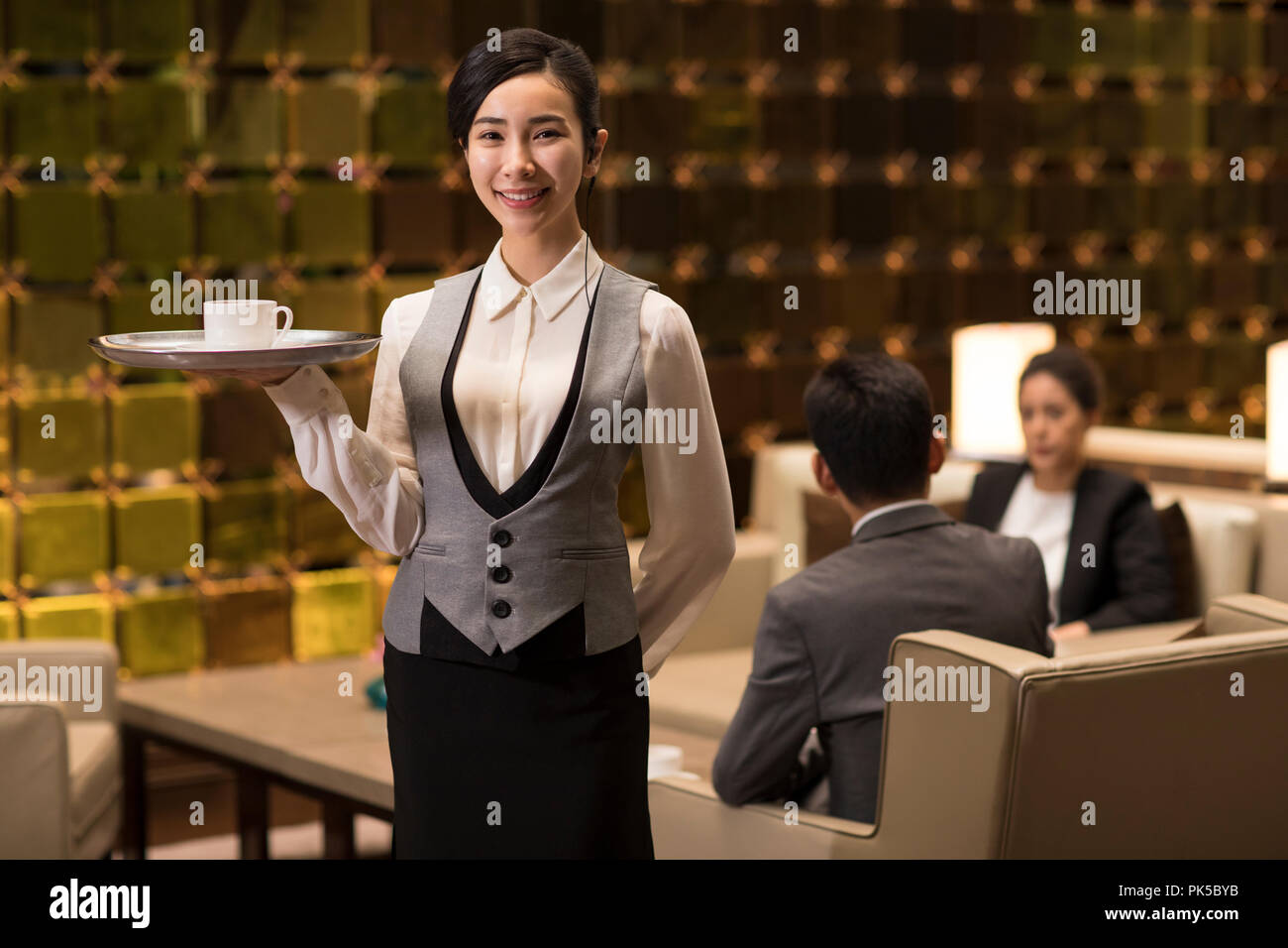 Cheerful young waitress serving coffee Banque D'Images