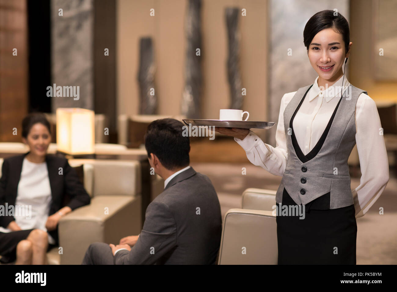 Cheerful young waitress serving coffee Banque D'Images