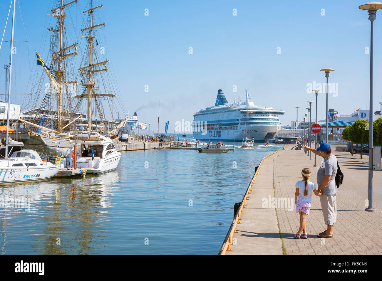 Père fille, vue arrière d'un père et sa fille se tenant la main sur le quai du port de Tallinn en regardant les bateaux et les navires, de l'Estonie. Banque D'Images