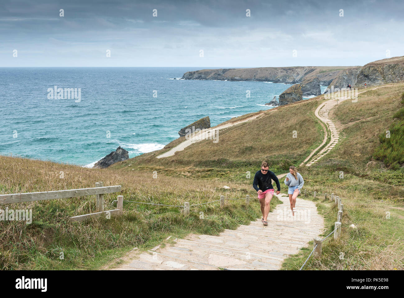 Les vacanciers grimpant suit sur le South West Coast Path au Bedruthan Steps sur la côte nord des Cornouailles. Banque D'Images