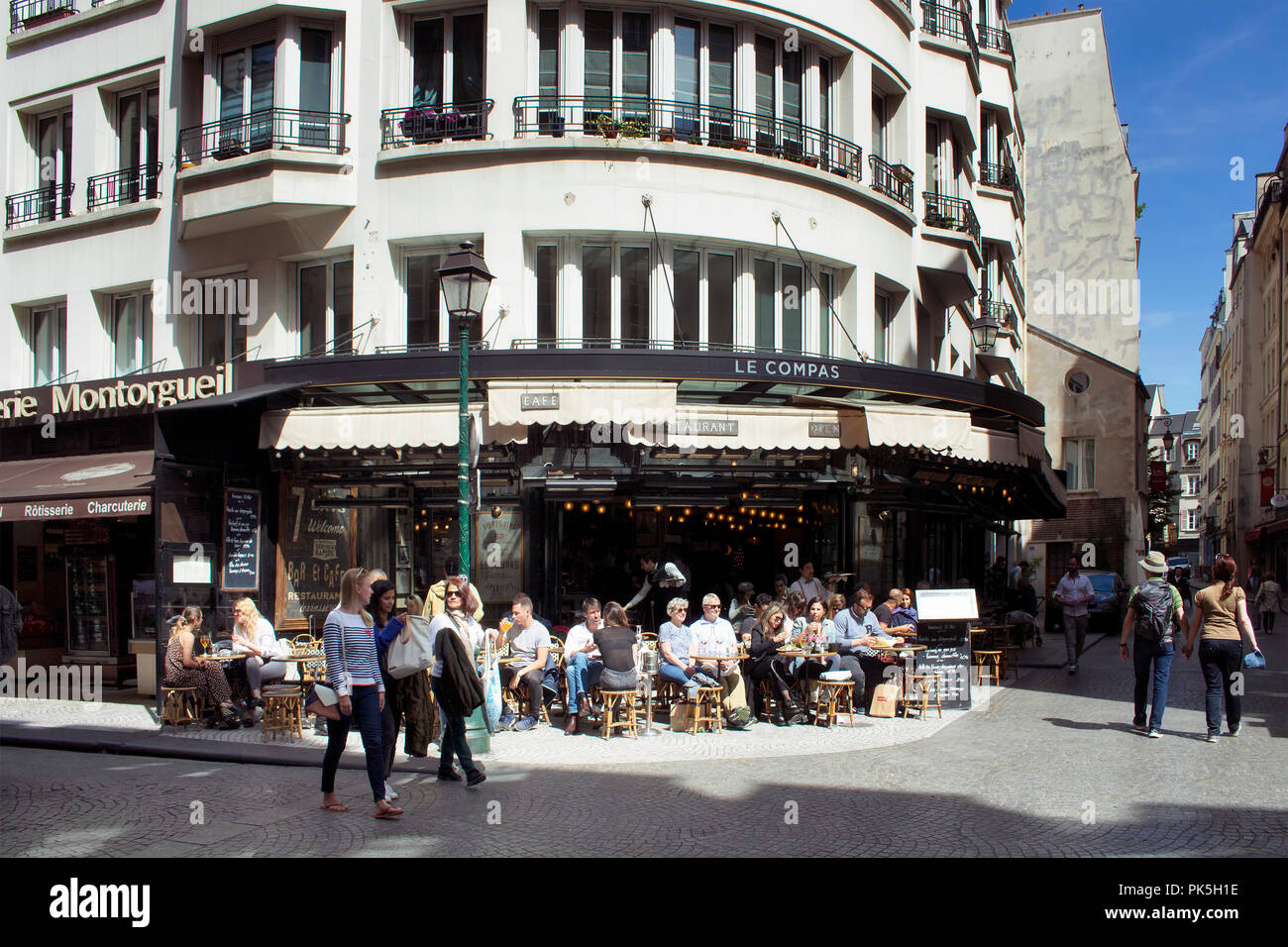 Les gens à pied sur la célèbre rue Montorgueil à Paris. Un café traditionnel / bistro place est aussi dans la vue. Banque D'Images