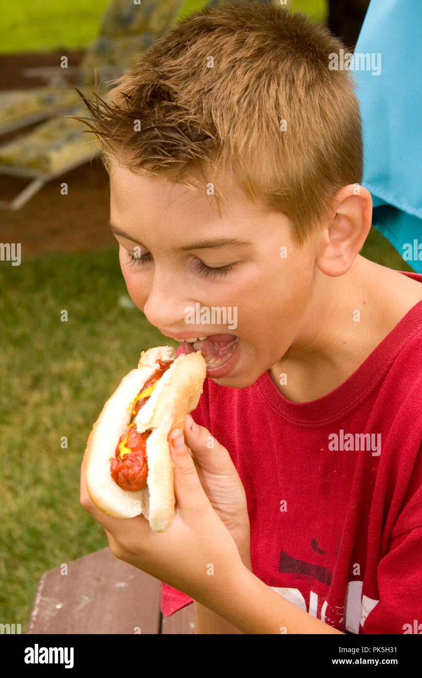 Boy eating hot dog américain. Image en gros plan. Banque D'Images