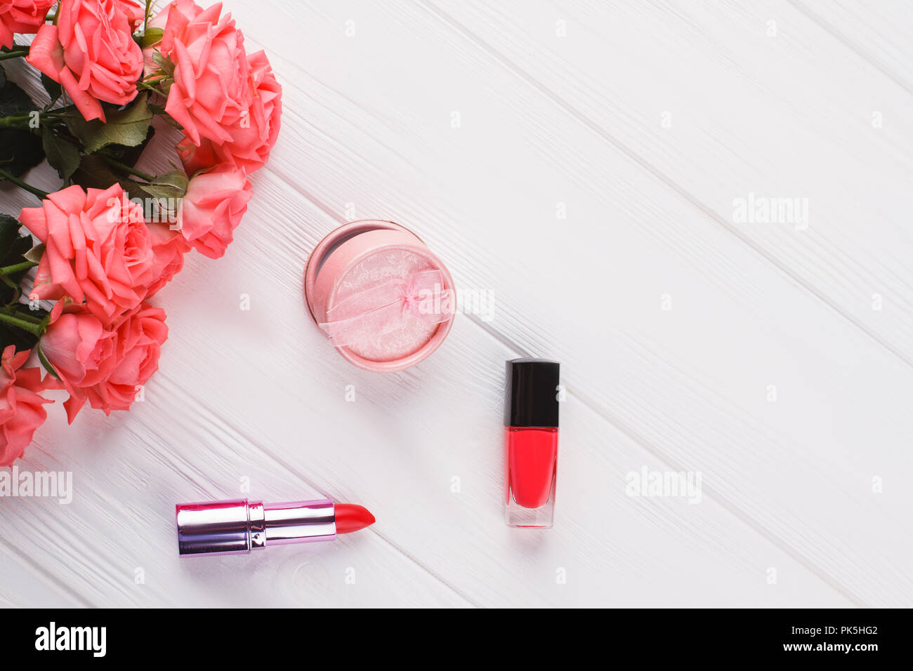 Les accessoires de maquillage et de rose des fleurs. Fond en bois blanc. Haut de la vue, télévision lay. Banque D'Images